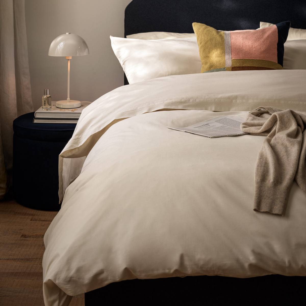 سرير مفروش بأغطية أسرّة بلون كريمي